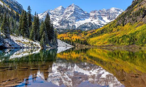 Maroon Bells and Maroon Lake - A wide-angle autumn midday view of snow coated Maroon Bells reflecting in crystal clear Maroon Lake, Aspen, Colorado, USA.